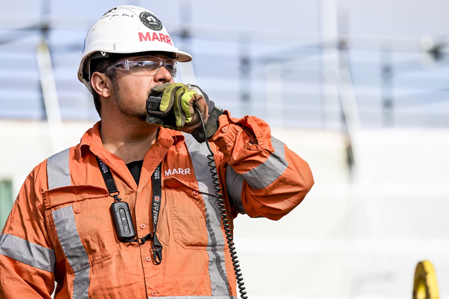 Crew member calling on a radio while wearing The Buddie System lanyard