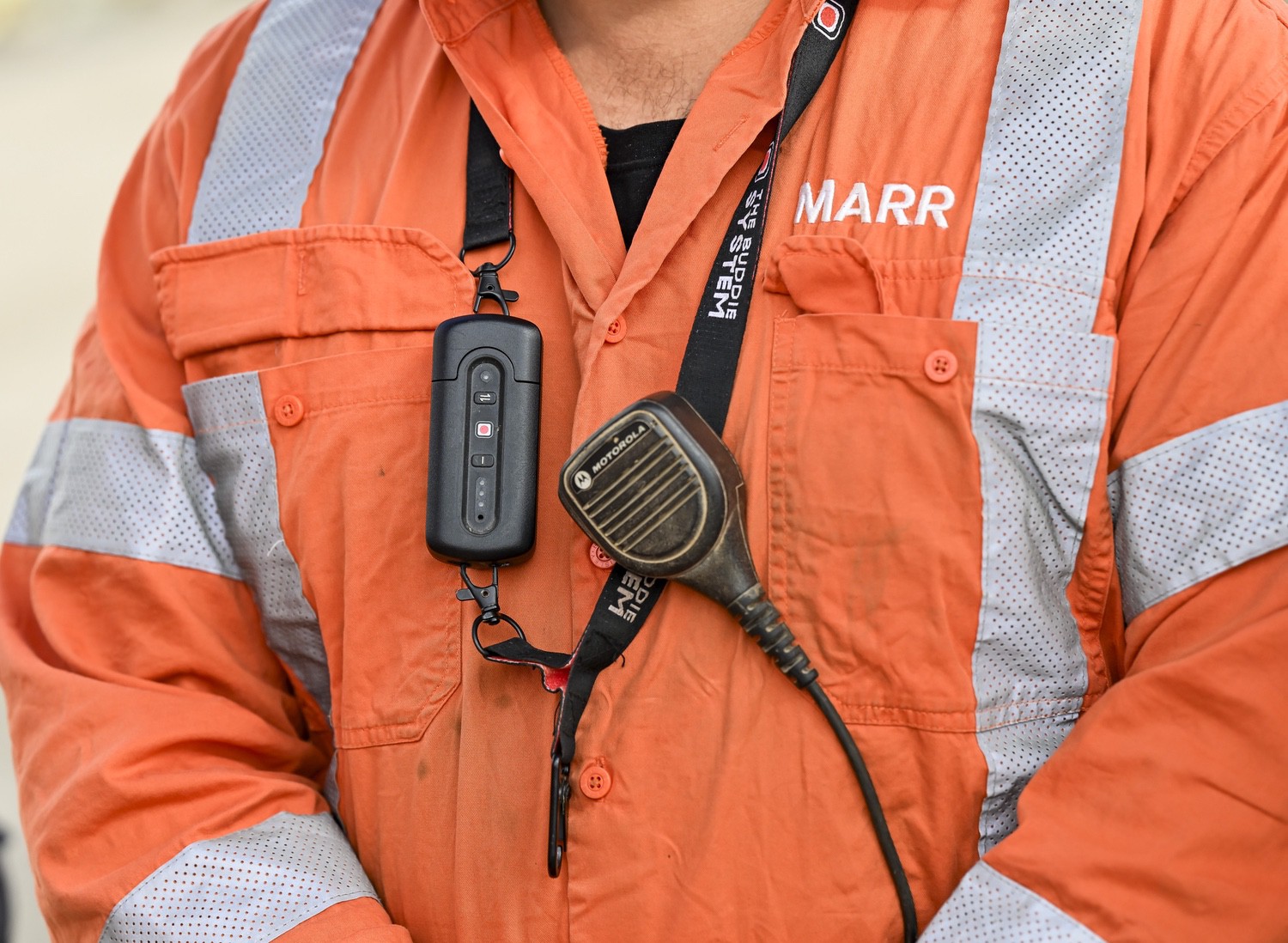Rigger wearing The Buddie System pull device alongside a Motorola two-way radio