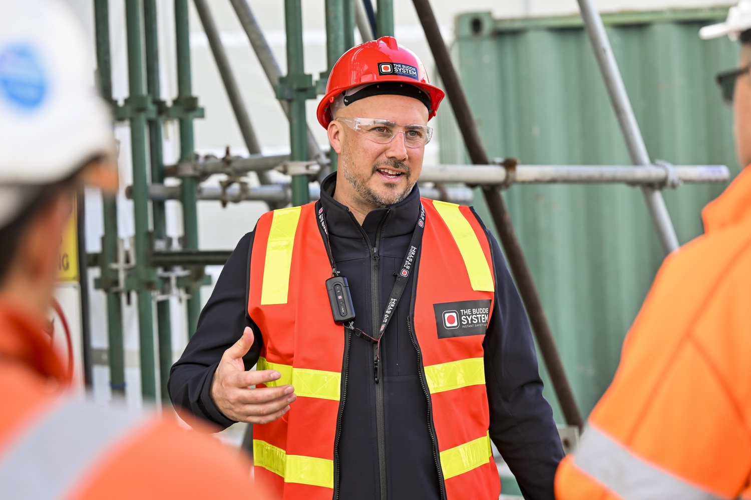 Supervisor briefing crew members on a jobsite while wearing The Buddie System